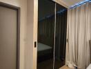 Bedroom with mirrored wardrobe and light curtains