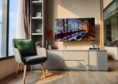 A cozy living room with a modern television and comfortable chair.