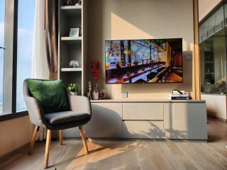 A cozy living room with a modern television and comfortable chair.