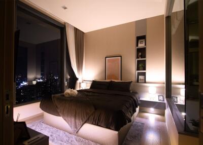 Modern bedroom with large window and city view at night