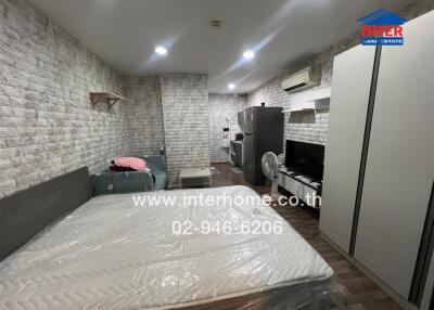 Bedroom with brick wall design, bed, sofa, and appliances