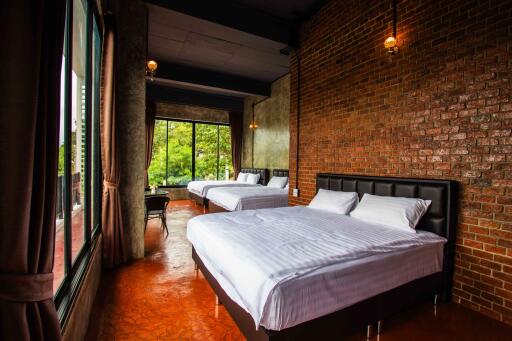 Spacious bedroom with brick walls and large windows