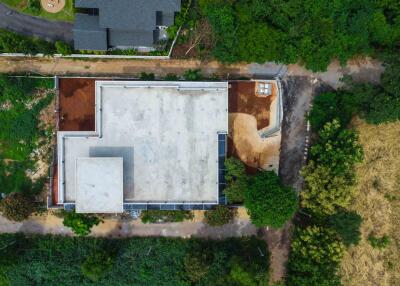 Aerial view of a large building under construction surrounded by greenery