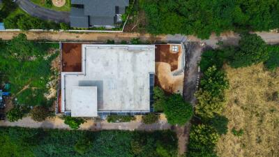 Aerial view of a large building under construction surrounded by greenery