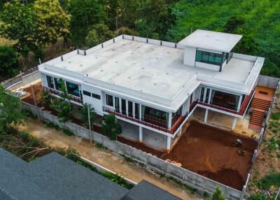 Aerial view of a large modern two-story house with a flat roof