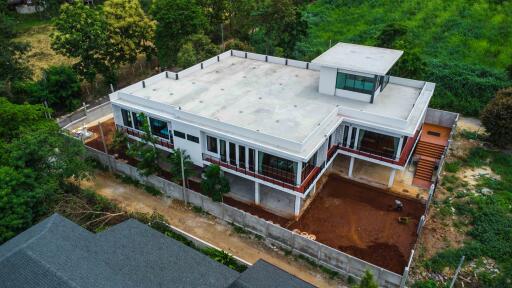 Aerial view of a large modern two-story house with a flat roof