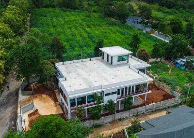 Aerial view of a large modern building with surrounding greenery