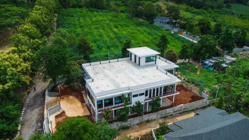 Aerial view of a large modern building with surrounding greenery