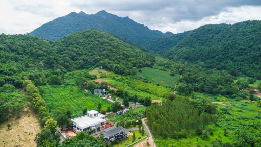 Aerial view of property in lush green mountainous area