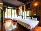 Bedroom with two large beds, exposed brick wall, and large windows