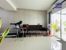 Modern living room with a brown sofa, exercise equipment, and sliding glass doors leading to an outdoor area