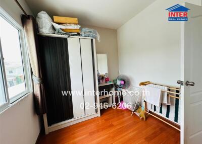 Small bedroom with window, wardrobe, and hardwood floor