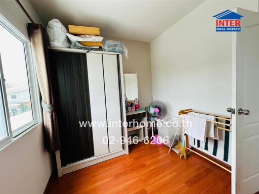 Small bedroom with window, wardrobe, and hardwood floor