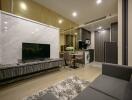 Modern living area with marble accent wall, flat-screen TV, and integrated kitchen in the background