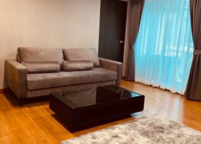 Modern living room with a gray sofa and glass coffee table