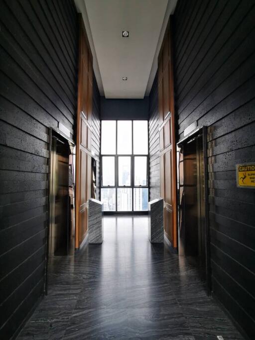 Modern building corridor with two elevators and large window