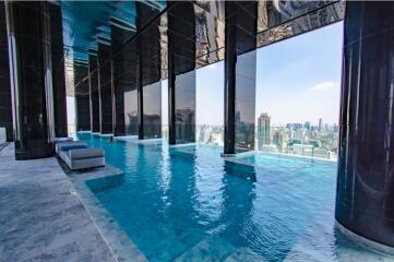 High-rise building with an infinity pool overlooking the city.