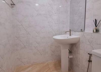 Modern bathroom with white tile walls and wooden floor tiles