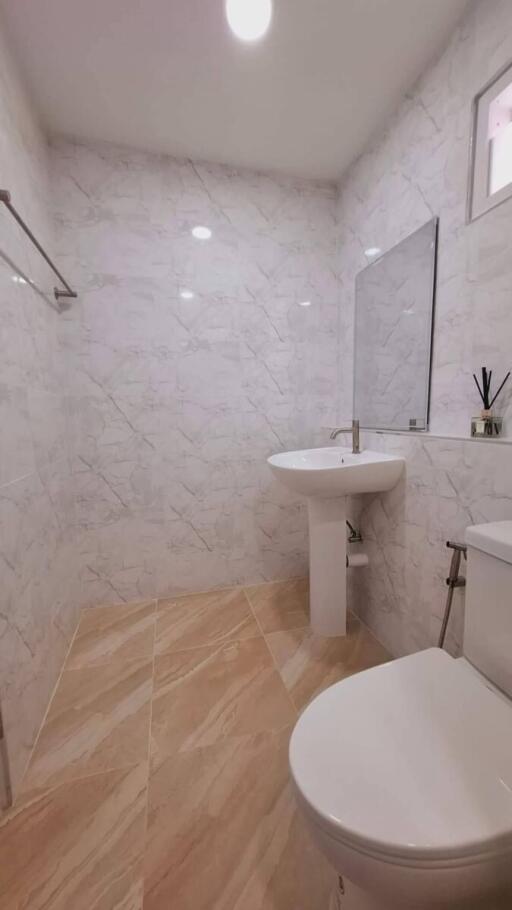 Modern bathroom with white tile walls and wooden floor tiles