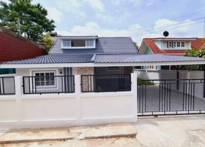 Front view of a residential house with a gated parking area