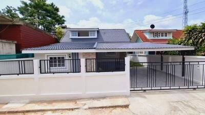 Front view of a residential house with a gated parking area