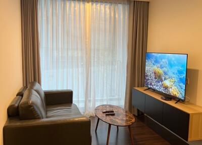 cozy living room with couch, coffee table, TV, and large window