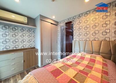 Modern bedroom with patterned wallpaper, built-in wardrobe, and air conditioning unit