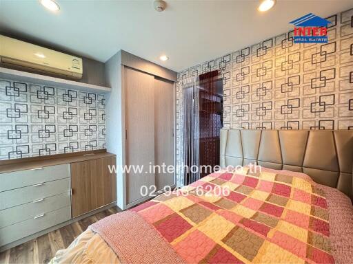 Modern bedroom with patterned wallpaper, built-in wardrobe, and air conditioning unit