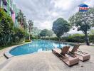 Swimming pool with lounge chairs and surrounding greenery