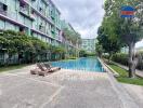 Outdoor view of residential building with a swimming pool and landscaped surroundings