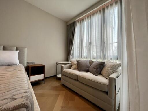 Cozy bedroom with bed and sofa near a large window