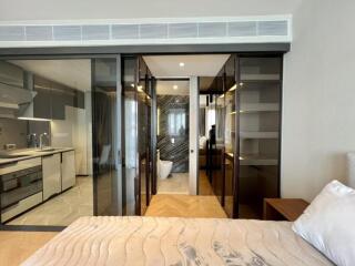 Modern bedroom view with ensuite bathroom and adjacent kitchen