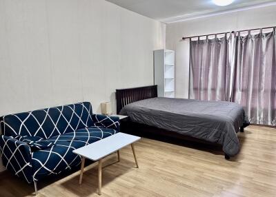 Spacious bedroom with a bed, couch, and coffee table