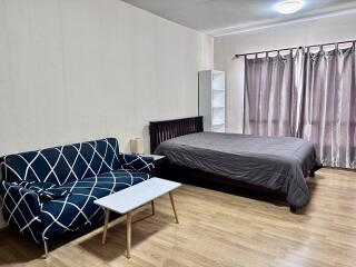 Spacious bedroom with a bed, couch, and coffee table