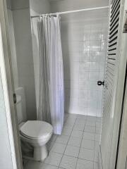 A clean and simple bathroom with a shower and curtain.