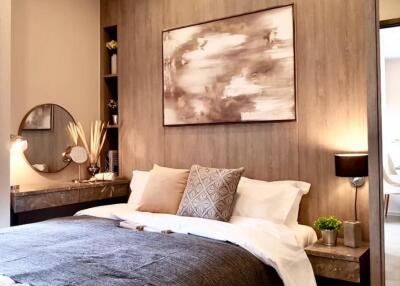 Modern bedroom with wall art, bedside tables, and lamps