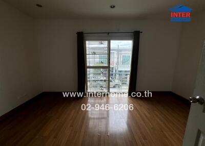 Unfurnished bedroom with wooden flooring and a window