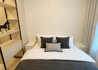 Bedroom with neatly made bed and open shelving