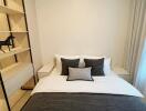 Bedroom with neatly made bed and open shelving