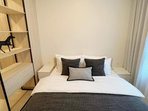 Bedroom with neatly made bed and open shelving