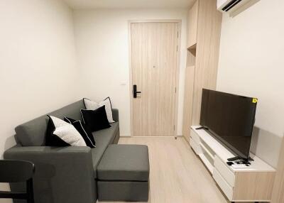 Modern living room with a gray sofa, TV and built-in air conditioner