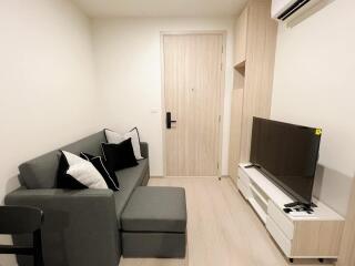 Modern living room with a gray sofa, TV and built-in air conditioner