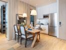 Modern dining area with wooden table and chairs next to a compact kitchen