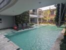 Outdoor pool area with lounge chairs and greenery