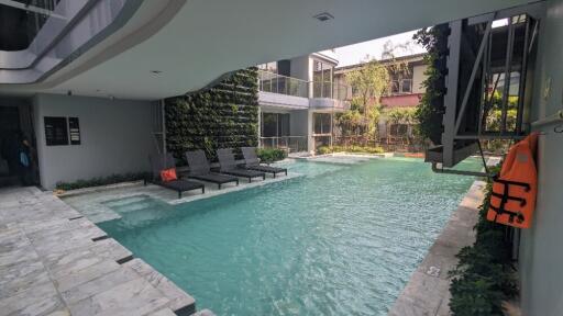 Outdoor pool area with lounge chairs and greenery