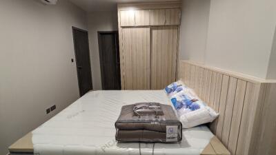 Modern bedroom with wooden wardrobe and bed with clean linens