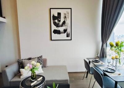 Modern living and dining area with a sofa and a dining table set for two