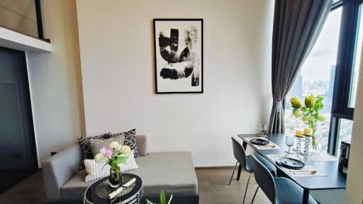 Modern living and dining area with a sofa and a dining table set for two