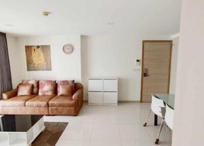 Living room with brown couch, wall art, and glass coffee table