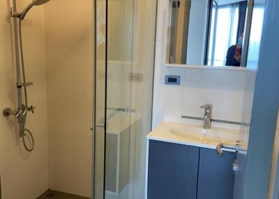 Modern bathroom with glass shower, sink, and vanity